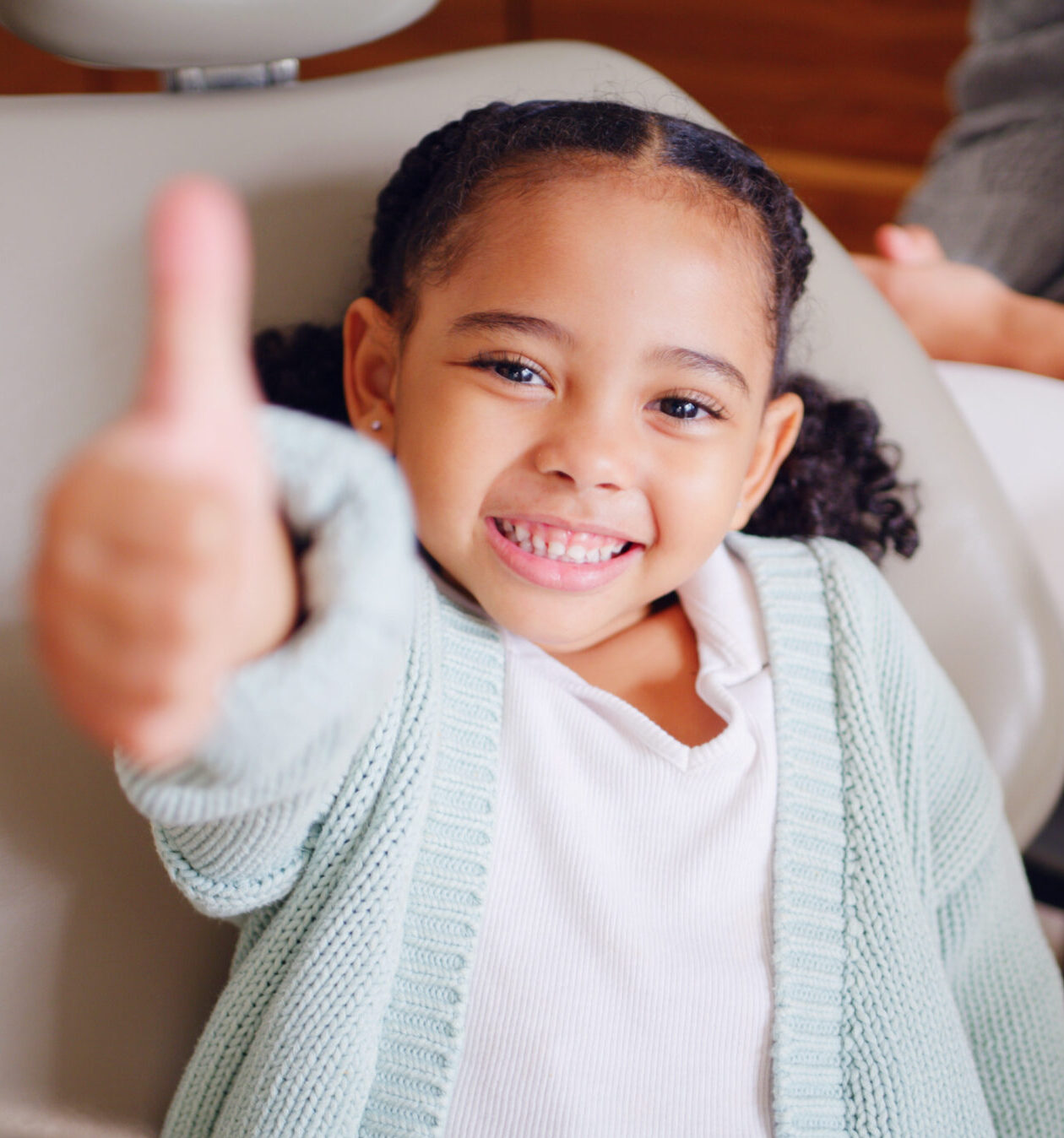 Portrait, smile and thumbs up with girl at dentist for optometry goals, success or support. Emoji, hand gesture and motivation with child in chair at dental clinic for healthcare or wellness.