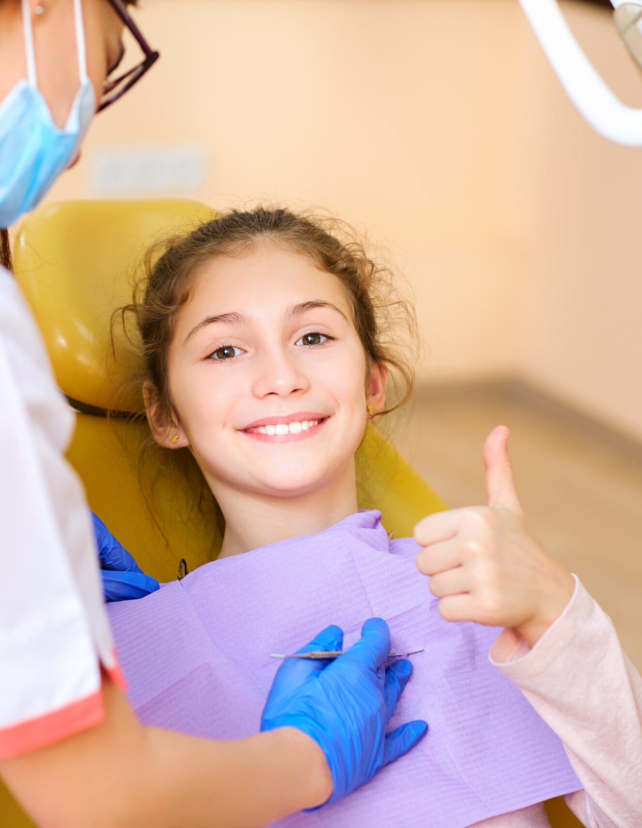 Woman dentist treats your child's teeth in the dental office.
