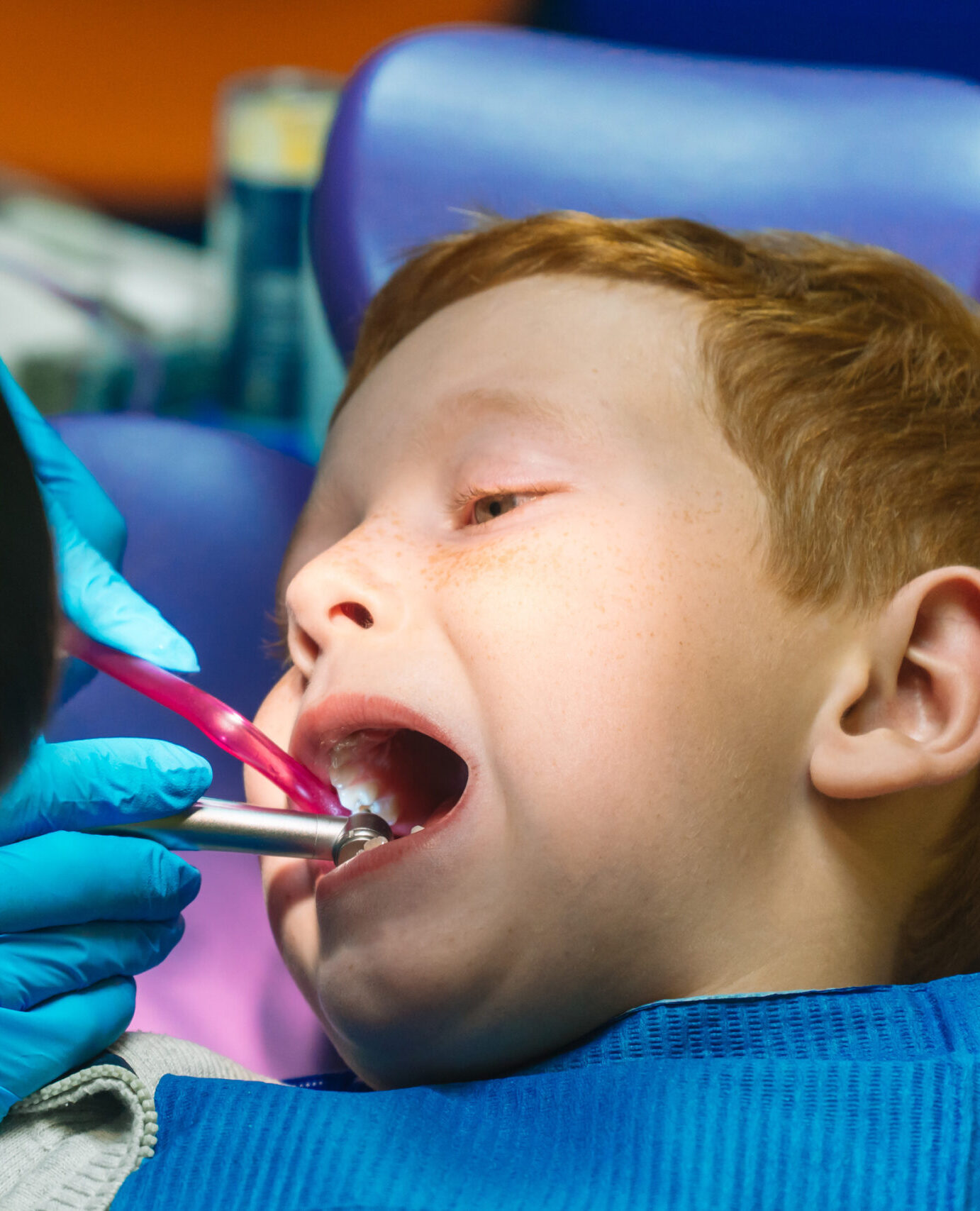 Scared red-haired boy crying at reception at dentist in dental chair