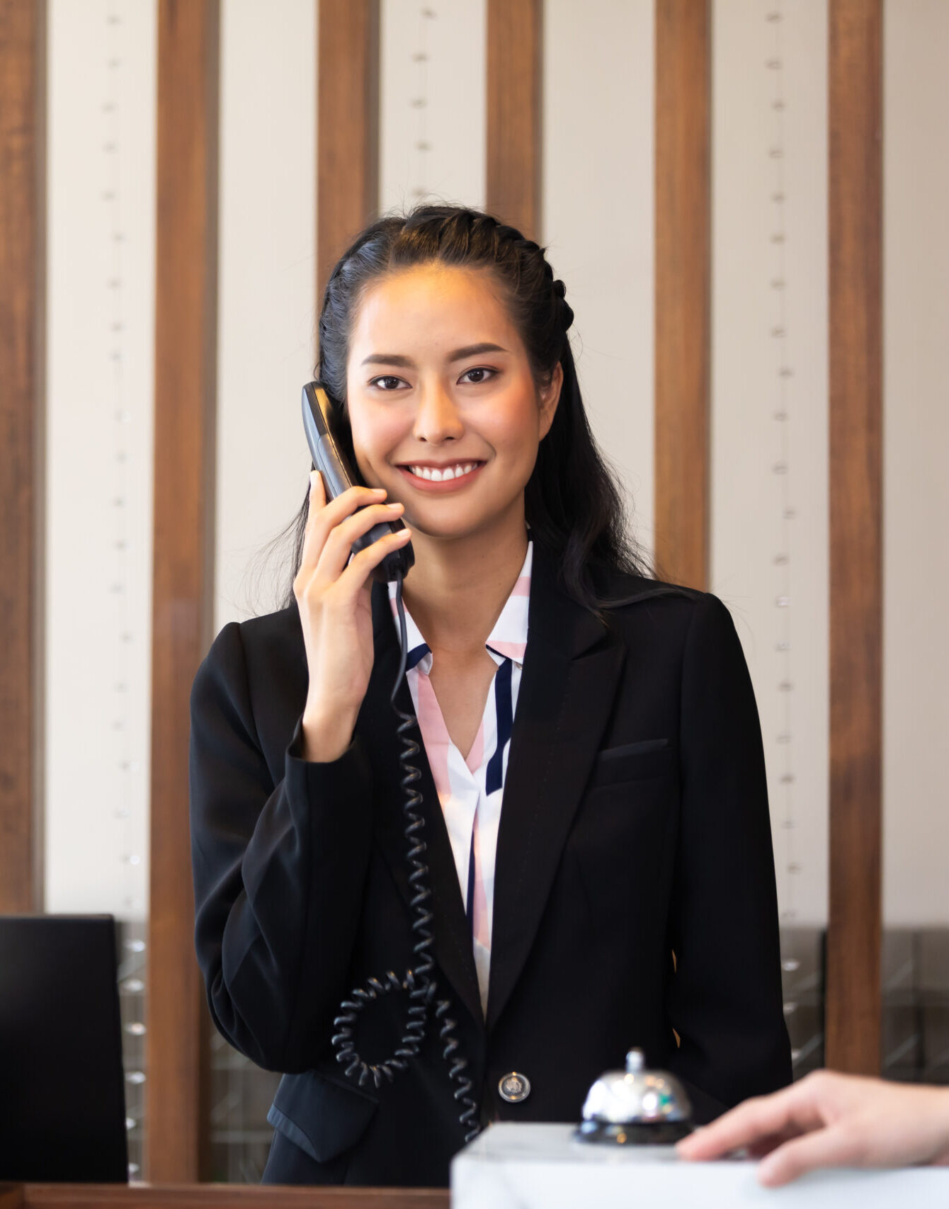 Friendly receptionist woman working at desk in hotel lobby. Leisure and travel at holidays.