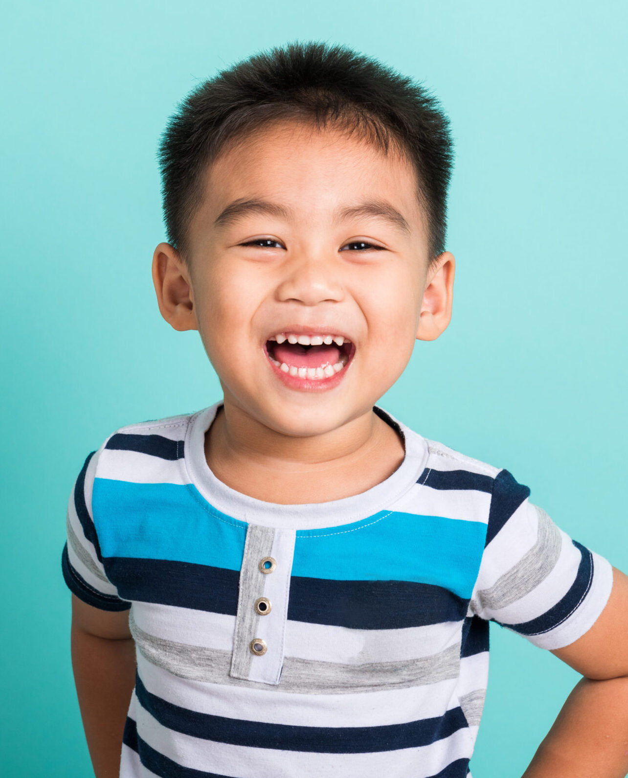 Asian portrait of cute little boy kid happy face he laughing smiles and looking to camera, studio shot isolated on blue background