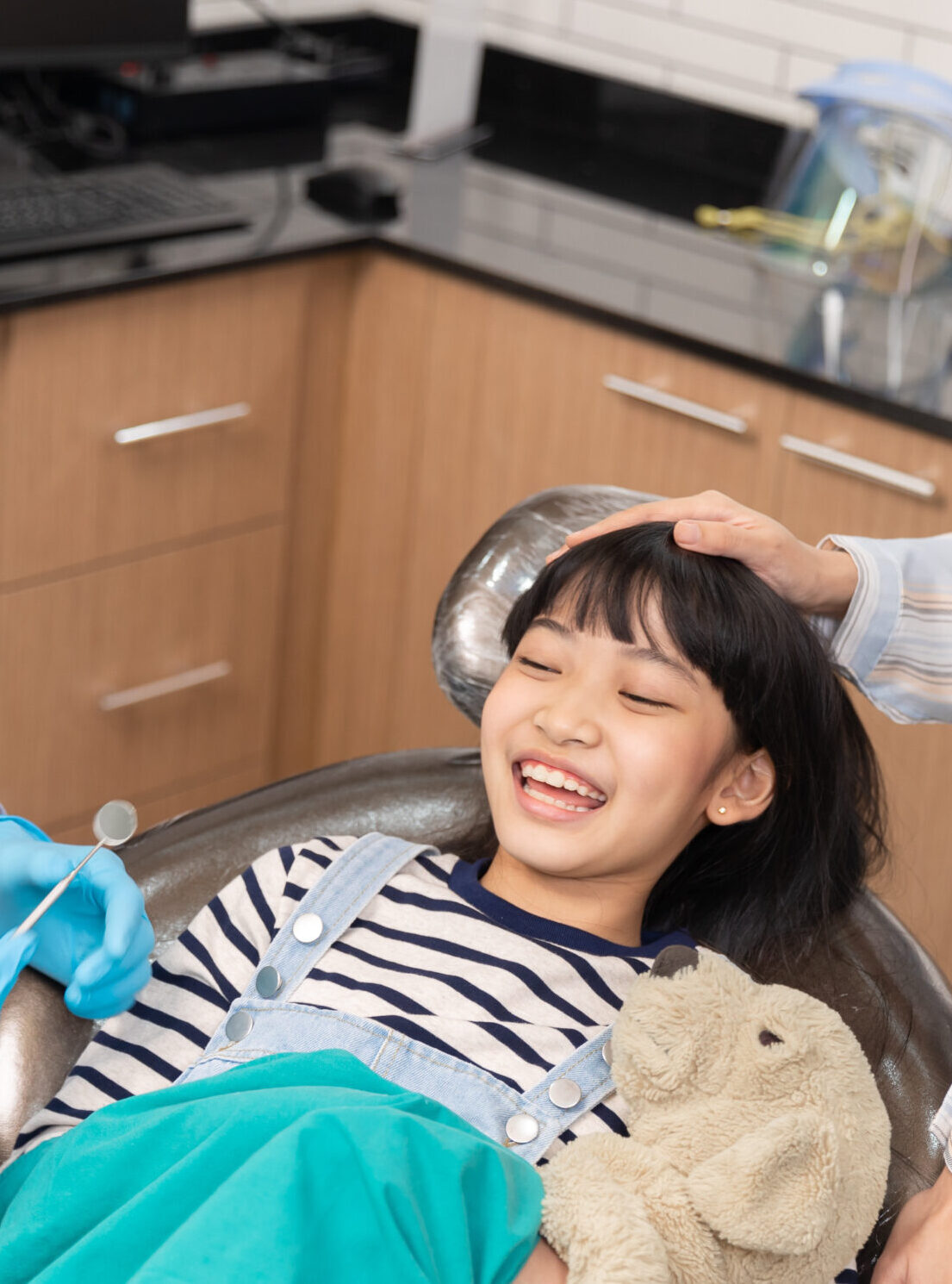 Happy asian male dentist with patient girl at clinic.Asian children's dentistry for healthy teeth and beautiful smile .