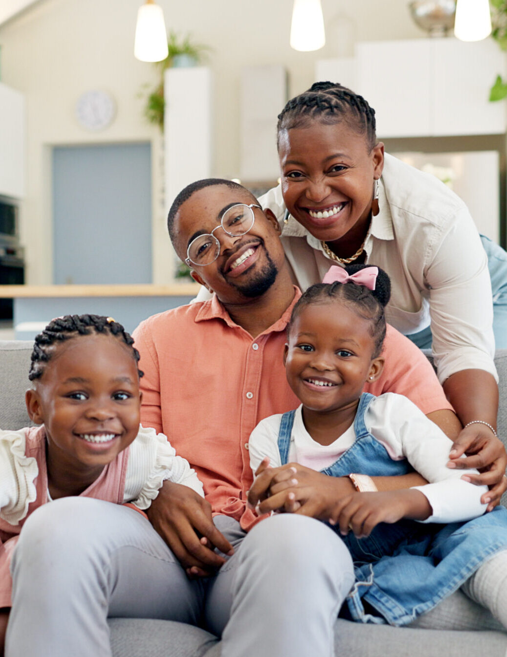 Happy, black family on sofa and in living room of their home happy together for care. Support or love, happiness or positivity and African people cuddle on couch in their house for bonding time.